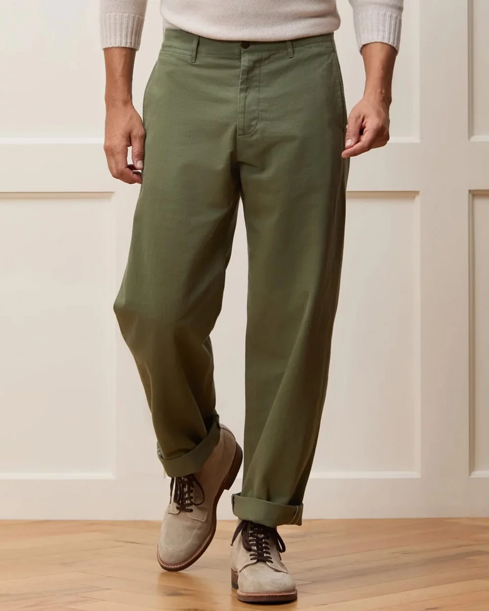 Man in olive trousers and tan lace-up shoes standing