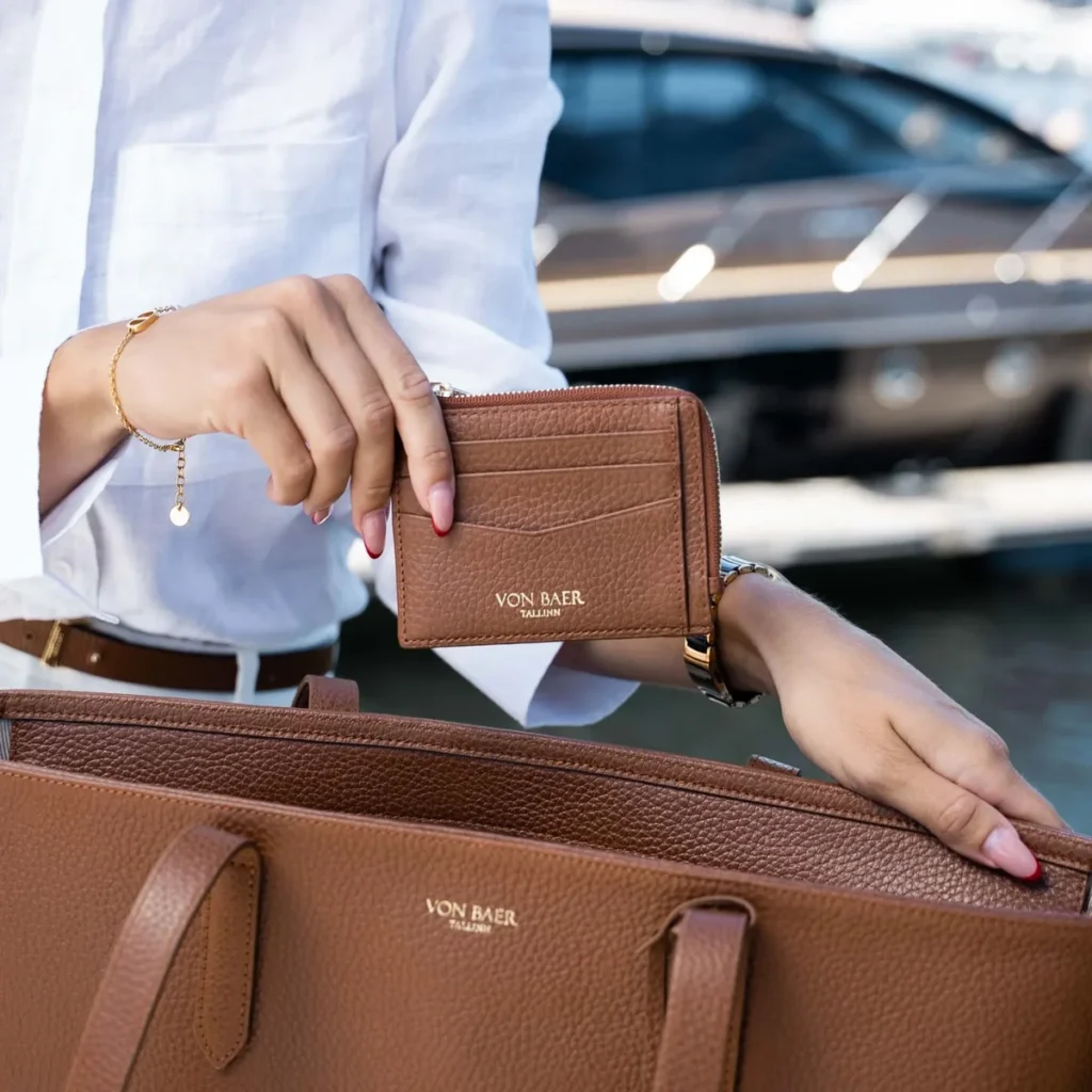 Woman holding a structured tan leather work tote bag