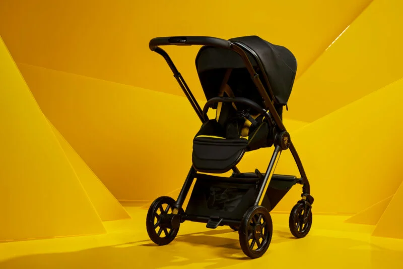 Black stroller with yellow accents on a yellow geometric background