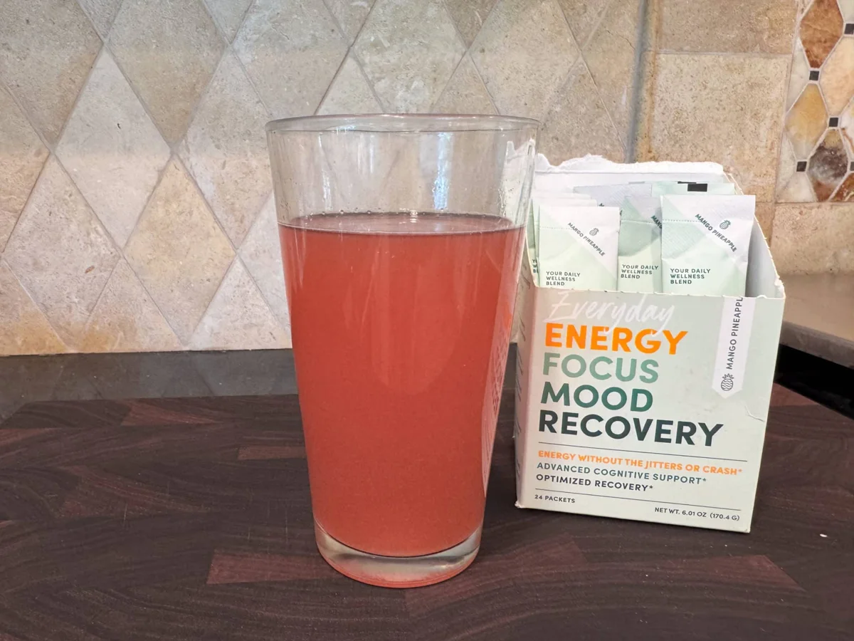 Glass of red energy drink with wellness packets