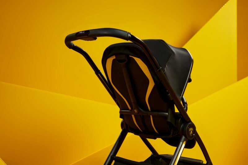 Black stroller with yellow accents against a vibrant yellow background